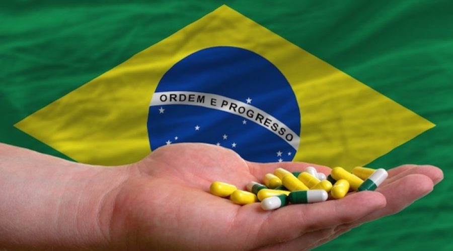CREDIT: <a href="http://www.shutterstock.com/pic-106093970/stock-photo-man-holding-capsules-in-front-of-complete-wavy-national-flag-of-brazil-symbolizing-health-medicine.html">Shutterstock</a>