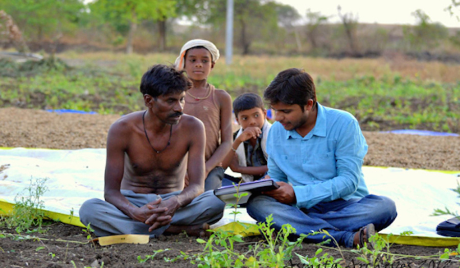 Asmita worker with farmer and his family. Photo courtesy of Asmita