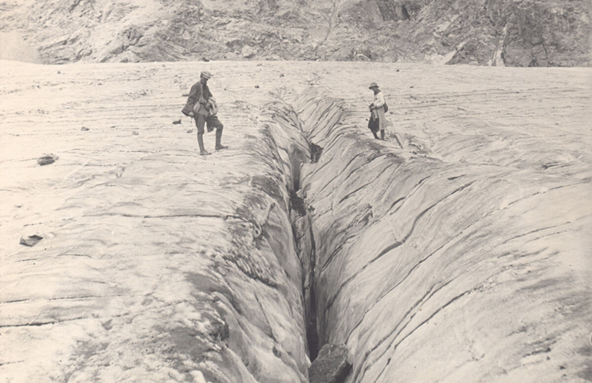 Standing between a giant fissure on a glacier, December 31, 1918. CREDIT: <a href="https://commons.wikimedia.org/wiki/Category:1919#/media/File:Standing_Between_A_Giant_Fissure_in_Glacier.jpg"> University of Colorado, Boulder</a>