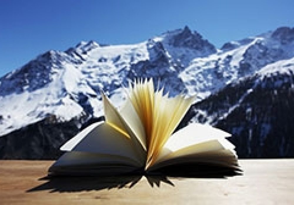 opened book in foreground, mountains in back