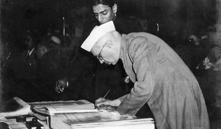 Jawaharlal Nehru signing the Indian Constitution in 1950.